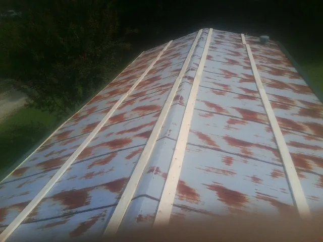 Rusted metal roof panels with new wood purlins before replacement — Storm Damage Roof Repair in Waynoka by Roofing Brothers