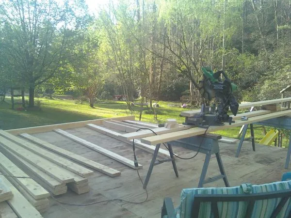 Miter saw and framing lumber on a deck under construction in Waynoka