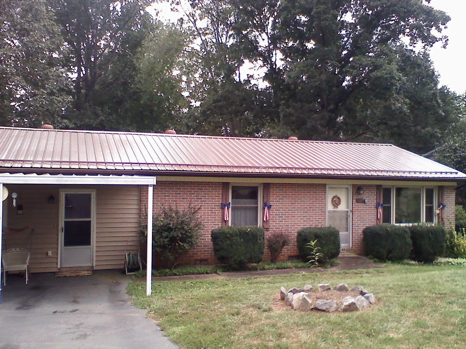 Bronze metal roof and carport on a brick ranch home — Roof Repair work by our crew in Waynoka